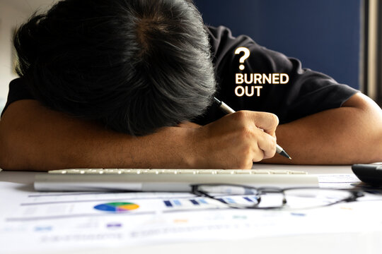 Burned Out Office Worker Resting at Desk with Financial Reports and Keyboard
