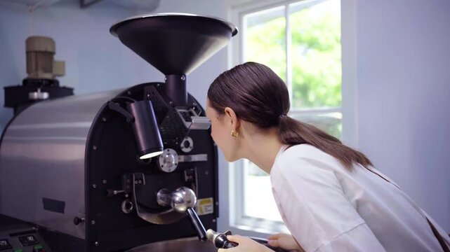 Female roaster inspecting coffee roasting machine before use