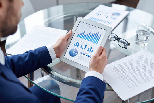 Business Professional Reviewing Financial Report on Digital Tablet