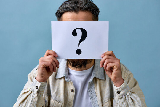 Homme cachant son visage derri&egrave;re une feuille avec un point d'interrogation. Concept de recrutement, recherche de talent, candidat myst&egrave;re ou choix d'employ&eacute; sur fond bleu.