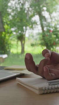 Close Up of Hand Counting Fingers for Relaxation, Mindfulness and Focus at Workspace with Green Nature Bokeh Background