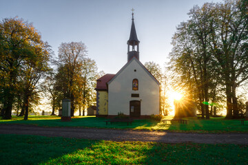 Front kościoła pw. Narodzenia NMP na Szwedzkiej Górce (opolskie) w blasku wschodzącego słońca. Ciepłe światło (złota godzina) podkreśla sielski, autentyczny charakter sakralnej architektury. © Henryk Niestrój
