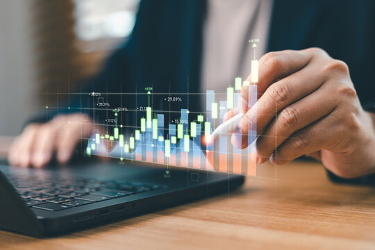 Trader using stylus to analyze financial stock market candlestick chart on laptop. Concept of digital investment, cryptocurrency trading, forex data analysis and profit growth
