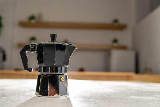 Black moka pot brewing espresso coffee in kitchen