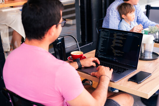 Coder working remotely from cafe using laptop 