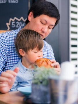 Father and son sharing breakfast at cafe 