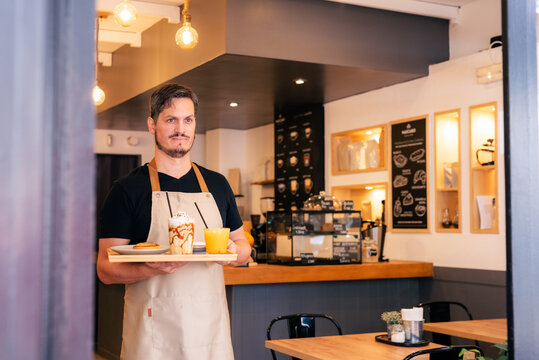 Waiter carrying drinks at cafe 