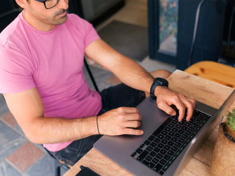 Man Works on Laptop at a Cafe During Daytime