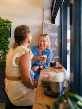 Women talking and laughing at cafe 