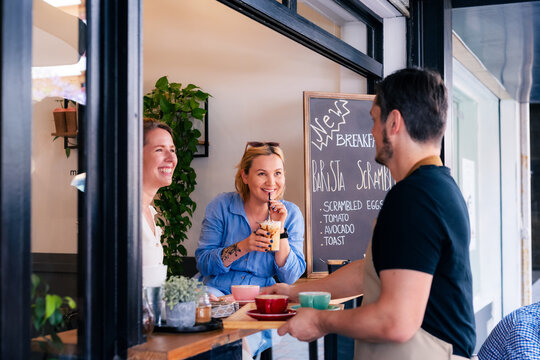 Guests appreciating service from barista at cafe 