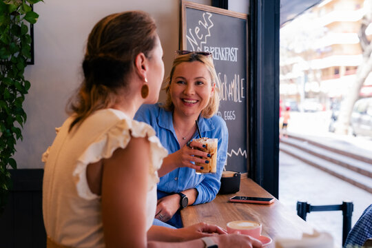 Best friends enjoy drinks at cafe 