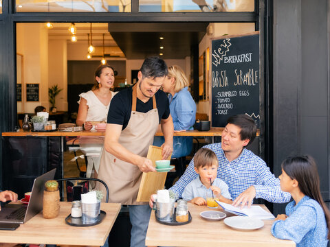 Waiter serving guests at sidewalk cafe 