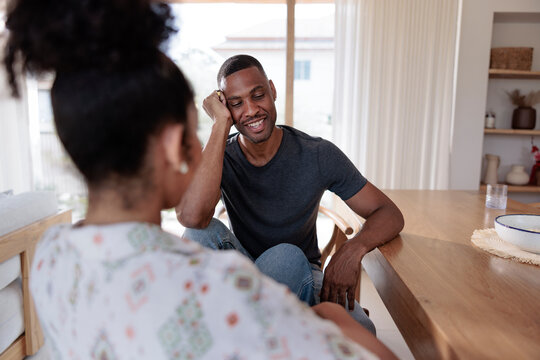 Couple conversing at a table, man smiling.