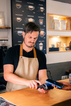 Barista Takes Payment at Coffee Shop 