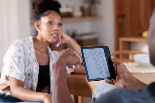 Man sharing content from an e-reader with a woman