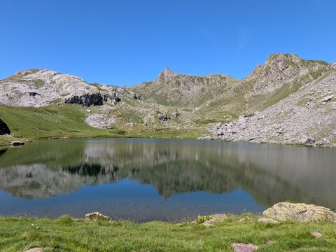 Splendid reflection of rocky peaks in Lac de Casterau, Pyrenees, France