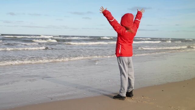 Little girl walks along shore of Baltic Sea