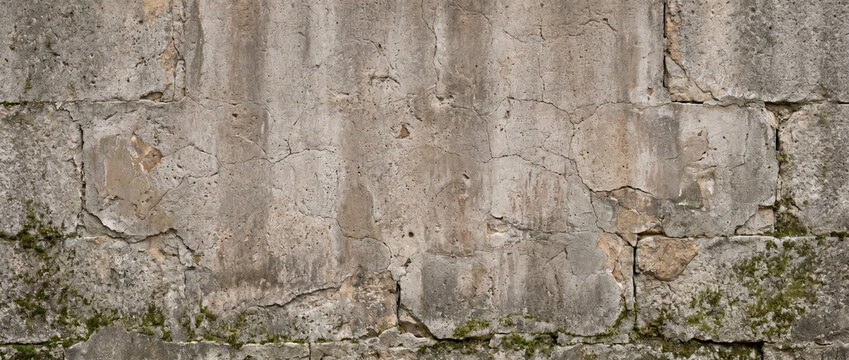 Weathered Cracked Stone Plaster Wall Texture with Aged Rustic Surface and Moss Background