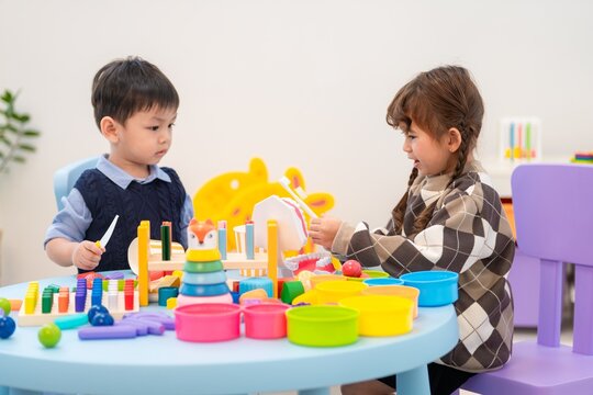 Children play with colorful toys at a table during a group activity in a learning center