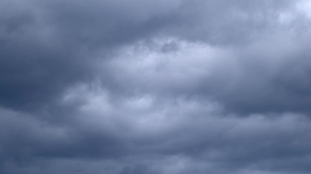 Dark storm clouds rolling across overcast sky before storm, timelapse