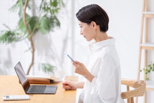 スマホとパソコンを使う女性