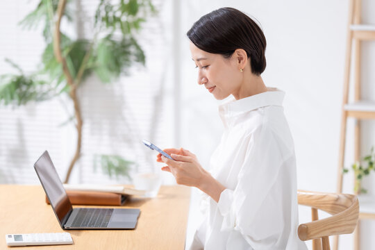 スマホとパソコンを使う女性