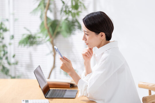 スマホを見て悩む女性