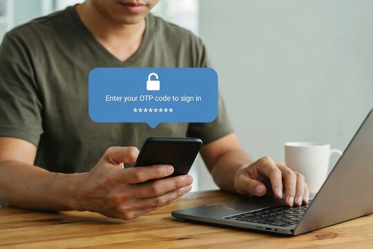 Man using smartphone and laptop to enter otp code for secure two factor authentication login