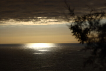 Golden sunset reflecting across the Atlantic Ocean beneath dramatic clouds © Gabriela