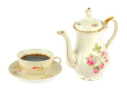 Vintage porcelain coffee pot and cup with black coffee isolated on a white background.