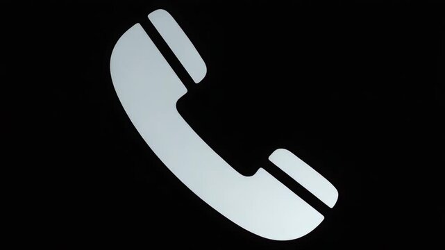 A clean white telephone receiver icon stands out against a stark black background symbolizing communication contact and support 4k video