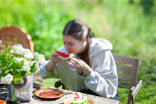 irl eating watermelon in a garden