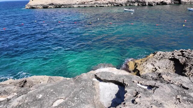 Rugged coastline, salt and calm sea in a sunny day in Xlendi bay, Munxar, Gozo,Malta. High quality 4k footage