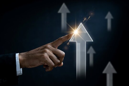 Businessman hand pointing at a glowing rising arrow icon representing business growth success