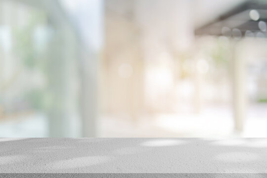 abstract blurred garden view form living room window with modern plain concrete table counter background for show , promote ,design banner ads on display concept