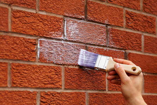 Applying Waterproof Sealant to a Brick Wall