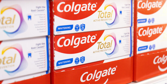 Colgate logo on fluoride toothpaste dental brand. Colgate Total oral hygiene health product by American multinational consumer company Colgate-Palmolive on supermarket retail store shelf.