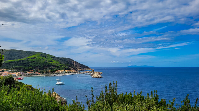 Panoramic view of Marciana Marina harbor, historic watchtower and coastline on Elba Island in Tuscany, Italy.