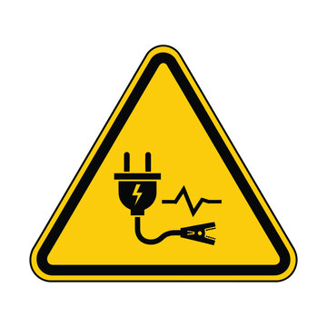 Yellow triangular warning sign with black border depicting an electrical plug, lightning bolt, and alligator clip, symbolizing electrical hazard.