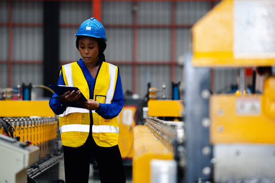 Female industrial engineer. Industrial quality inspection. Female factory worker checking production line equipment in a manufacturing plant. Factory, inspection, manufacturing, engineer, safety.