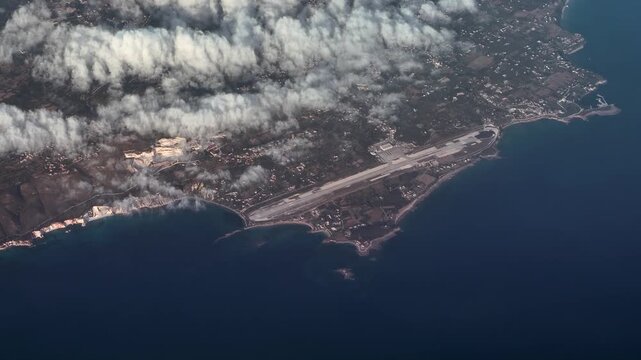 flying along Kefalonia Airport "Anna Pollatou" (IATA: EFL, ICAO: LGKF) an airport on the island of Cephalonia, in Greece, with runway, taxiway, apron and terminal building - 4k aerial video footage
