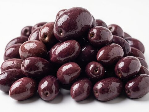 A large pile of fresh dark kalamata olives stacked together on a flat surface for a healthy mediterranean food snack isolated on white background