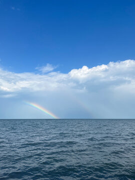 Vibrant Rainbow Over Blue Sea Surface