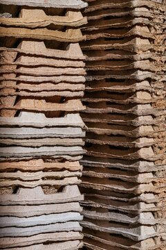 Stack of brown cardboard egg carton trays. Sustainable packaging material for recycling and waste management. Eco friendly paper pulp product for industrial storage and transportation.