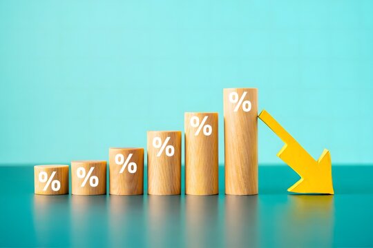 Wooden blocks with percentage signs and a downward arrow showing economic decline