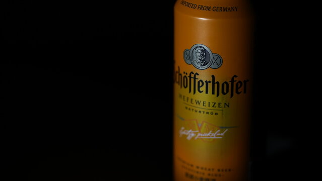 H&ouml;fferhofer Hefeweizen beer bottle with visible brand label photographed in dark atmospheric lighting, editorial food and beverage image