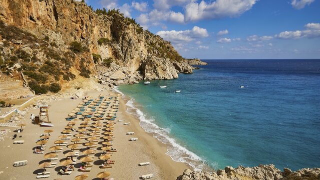 A wide view of a coastline with a beach lined with parasols and turquoise blue water, Kyra Panagia, Kyra Panagia Beach, East Coast, Karpathos, Dodecanese, Greek Islands, Greece