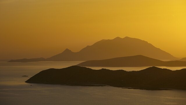 Golden sunset over the sea with silhouetted mountains in the background, Makri Island, Alimia Island, Chalki Island, Kritinia Castle, St John's Castle, Kritinia, Rhodes, Dodecanese, Greek Islands, Greece