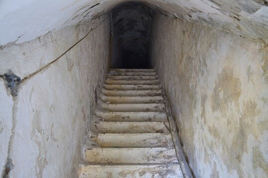 An old, narrow staircase leading deep into the darkness of an underground passage, Lost Place, Lago anti-aircraft battery, Bunker, Apitiki Mountain, Leros, Dodecanese, Greek Islands, Greece