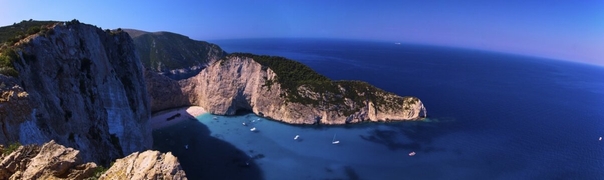 Paralia Navagio, Shipwreck Beach, panoramic photo, rocky cliff, shipwreck MV Panagiotis, excursion boats, blue and turquoise crystal clear sea, cloudless blue sky, Zakynthos, Ionian Islands, Greece